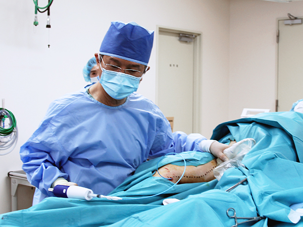 静脈を少し圧迫しながら、右手の注入用ガンで瞬間接着剤を注入します